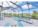 Beautiful screened-in pool and spa area with comfortable lounge chairs and views of a pond and other community homes at 17557 Santorini Ct, Venice, FL 34293
