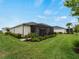 Exterior view of the home showcasing a well-maintained lawn, landscaping, and a screened patio at 17857 Woodland Ct, Punta Gorda, FL 33982
