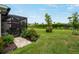 The backyard of this property features lush greenery, well-manicured landscaping, and a screened-in patio at 17857 Woodland Ct, Punta Gorda, FL 33982