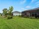 A spacious backyard features green lawn, tropical foliage, and a covered patio area, offering a serene outdoor space at 17857 Woodland Ct, Punta Gorda, FL 33982