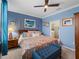 This primary bedroom features blue walls, decorative wall art, ceiling fan, and bench at 17857 Woodland Ct, Punta Gorda, FL 33982