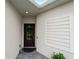 Charming front entrance with a classic door, sidelight, and gray tile walkway for welcoming curb appeal at 17857 Woodland Ct, Punta Gorda, FL 33982