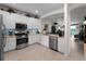 Kitchen showcasing stainless steel appliances, white cabinetry, granite counters, and a view of the dining area at 17857 Woodland Ct, Punta Gorda, FL 33982