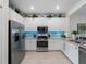 Bright kitchen featuring stainless steel appliances, white cabinetry, granite countertops, and mosaic backsplash at 17857 Woodland Ct, Punta Gorda, FL 33982