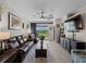 Bright living room with dark furniture, ceiling fan, and sliding glass doors to backyard at 17857 Woodland Ct, Punta Gorda, FL 33982