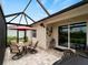 Screened in patio area with stone flooring, ceiling fan, and dining set, perfect for enjoying the outdoors at 17857 Woodland Ct, Punta Gorda, FL 33982