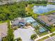 A stunning aerial view showcases a community pool, tennis courts, and picturesque lakefront scenery at 19821 Montenero Way, Venice, FL 34293