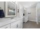 Bright bathroom with double vanity, framed mirrors, and tile flooring at 19821 Montenero Way, Venice, FL 34293