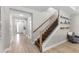 Hallway featuring staircase with wooden railing and open floor plan at 19821 Montenero Way, Venice, FL 34293