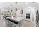 Open kitchen with a large island, modern lighting, stainless appliances and an adjacent dining area at 19821 Montenero Way, Venice, FL 34293