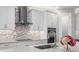 Modern kitchen with mosaic backsplash, stainless steel appliances, and quartz countertops at 19821 Montenero Way, Venice, FL 34293