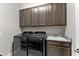 Laundry room with gray cabinets and modern washer and dryer at 19821 Montenero Way, Venice, FL 34293
