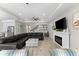 Bright living room with large sectional, electric fireplace, and light wood floors at 19821 Montenero Way, Venice, FL 34293