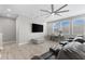 Bright living room featuring wood floors, a ceiling fan, and a comfortable gray ottoman at 19821 Montenero Way, Venice, FL 34293