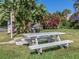Community picnic area with white picnic table, grill, and tropical foliage at 19821 Montenero Way, Venice, FL 34293