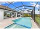 Outdoor living featuring a screened-in pool and spa with an outdoor kitchen and seating area at 19821 Montenero Way, Venice, FL 34293