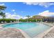 Community pool with plenty of lounge chairs and a beautiful blue sky at 19821 Montenero Way, Venice, FL 34293