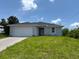 Charming single-story home featuring a two-car garage and a well-maintained lawn at 207 Baytree Dr, Rotonda West, FL 33947