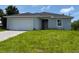Charming single-story home featuring a two-car garage and a well-maintained lawn at 207 Baytree Dr, Rotonda West, FL 33947