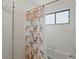 Bathroom with shower and tub combination and bright palm tree shower curtain at 219 Tait Se Ter, Port Charlotte, FL 33952