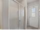 Bathroom featuring a modern glass enclosed shower and white paneled door to exterior at 219 Tait Se Ter, Port Charlotte, FL 33952