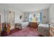 Twin bedroom with matching beds, dresser, a window with blue curtains, and adjoining bathroom at 219 Tait Se Ter, Port Charlotte, FL 33952
