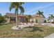 Desirable home with mature landscaping, a brick walkway, and an attached two-car garage at 219 Tait Se Ter, Port Charlotte, FL 33952