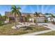 Charming home with a well-manicured lawn, lush landscaping, and a welcoming blue front door at 219 Tait Se Ter, Port Charlotte, FL 33952
