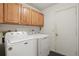 Functional laundry room with a white Maytag washer and dryer, and wood cabinets at 219 Tait Se Ter, Port Charlotte, FL 33952