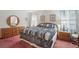 Bright main bedroom with wooden furniture, a patterned quilt, and natural light at 219 Tait Se Ter, Port Charlotte, FL 33952