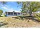 Backyard featuring a large shady tree, with a partial view of the home and its surroundings at 22299 Laramore Ave, Port Charlotte, FL 33952