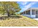 Backyard with a birdhouse and mature trees next to a screened lanai at 22299 Laramore Ave, Port Charlotte, FL 33952