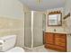 Bathroom featuring tiled shower, single sink vanity, and neutral wall color at 22299 Laramore Ave, Port Charlotte, FL 33952