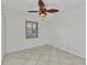 Bright bedroom with tile floors, neutral colors, and shuttered window at 22299 Laramore Ave, Port Charlotte, FL 33952