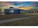 Exterior view of home with blue paint, simple landscaping, and a sidewalk in front at 22299 Laramore Ave, Port Charlotte, FL 33952