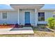 Welcoming front entrance with a bright blue door, neat landscaping, and a convenient walkway at 22299 Laramore Ave, Port Charlotte, FL 33952