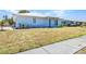 Quaint single-story home featuring a light blue exterior with small decorative garden bed and a concrete walkway at 22299 Laramore Ave, Port Charlotte, FL 33952