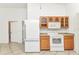 Bright kitchen featuring white appliances, wooden cabinets, and tile flooring at 22299 Laramore Ave, Port Charlotte, FL 33952