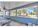 Enclosed lanai featuring outdoor ceiling fans and views of the lush backyard and nearby homes at 22299 Laramore Ave, Port Charlotte, FL 33952