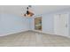 Neutral living room showcasing tiled flooring, natural lighting, and a ceiling fan at 22299 Laramore Ave, Port Charlotte, FL 33952