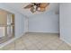 Bright living room with tiled flooring, neutral paint, ceiling fan, and natural light at 22299 Laramore Ave, Port Charlotte, FL 33952