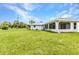 Exterior rear view of a well-kept single story home with a large backyard and screened in lanai at 229 Waterside St, Port Charlotte, FL 33954