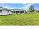Manicured backyard with a freshly mowed lawn wrapping around the rear of the home at 229 Waterside St, Port Charlotte, FL 33954