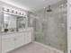Elegant bathroom featuring a frameless glass shower, marble walls, and a modern vanity with ample lighting at 229 Waterside St, Port Charlotte, FL 33954