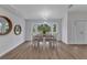 Bright dining area boasts wood flooring, stylish lighting, and views of the outdoors through a bay window at 229 Waterside St, Port Charlotte, FL 33954