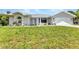 Well-maintained home featuring a clean white exterior, well manicured lawn, and an attached two car garage at 229 Waterside St, Port Charlotte, FL 33954