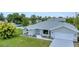 Well-maintained single story home featuring an attached two car garage, manicured lawn and attractive landscaping at 229 Waterside St, Port Charlotte, FL 33954