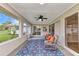 Relaxing screened patio with wicker chairs, a ceiling fan, and a view of the spacious backyard at 229 Waterside St, Port Charlotte, FL 33954