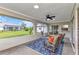 Screened patio featuring wicker chairs with bright pillows and a clear view of the well-maintained backyard at 229 Waterside St, Port Charlotte, FL 33954