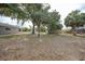 Expansive backyard area showcasing large trees and the home's exterior, creating a serene outdoor setting at 23165 Glen Ave, Punta Gorda, FL 33980